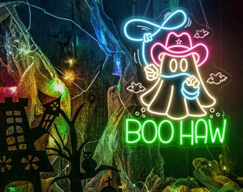 May include: A neon sign with a ghost wearing a cowboy hat and lasso, with the text "BOO HAW" underneath. The sign is hanging in front of a dark background with a black silhouette of a house and a tree.