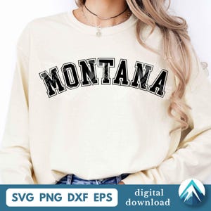 Puede incluir: Una sudadera de manga larga de color crema con la palabra MONTANA impresa en una fuente negra, negrita y arqueada de estilo universitario en el pecho. La prenda tiene cuello redondo y mangas largas, ofreciendo un aspecto sencillo y limpio.