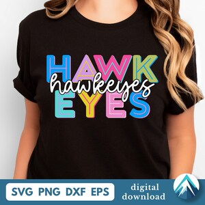 May include: Black t-shirt with the word "HAWKEYES" in colorful block letters and the word "hawkeyes" in cursive script. The shirt also has the words "EYES" in block letters. Below the shirt are the words "SVG PNG DXF EPS" and "digital download".