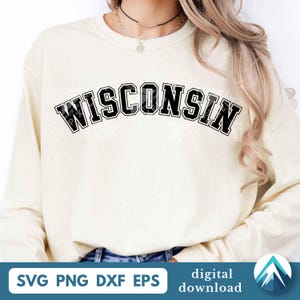 Puede incluir: Una sudadera de manga larga de color crema con la palabra WISCONSIN impresa en una fuente negra, negrita y arqueada de estilo universitario en el pecho. La prenda tiene cuello redondo y mangas largas, ofreciendo un aspecto sencillo y limpio.