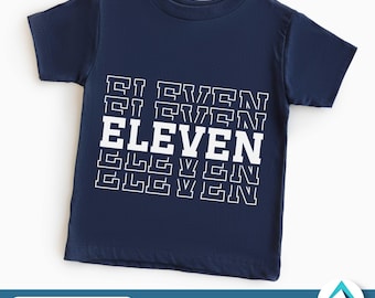 Könnte beinhalten: Ein marineblaues T-Shirt mit einem weißen Grafikdesign, auf dem "ELEVEN" in einem sich wiederholenden Muster steht.