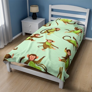 Könnte beinhalten: Ein hellgrüner Bettbezug in Twin-Größe mit einem sich wiederholenden Muster aus braunen Affen, die grüne Blätter tragen. Die Affen sind in verschiedenen Posen, einige sitzen, einige stehen und einige schwingen.