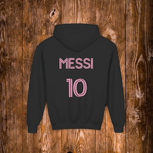 May include: Black hooded sweatshirt with pink lettering that says "MESSI 10" on the back.