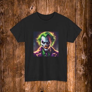 May include: A black short-sleeved t-shirt featuring a central graphic print of a character with bright green hair, white face paint, dark eye makeup, and a wide, toothy grin, wearing a purple jacket over a green shirt and a dark purple tie.