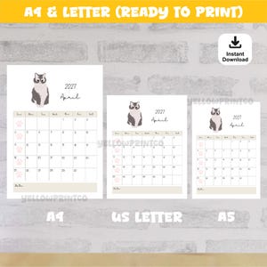 May include: A printable 2027 April calendar page featuring a grey and white cat illustration at the top. The grid displays dates from 1 to 30 with small pink paw prints in the Sunday column. The text includes 2027, April, and Note at the bottom.