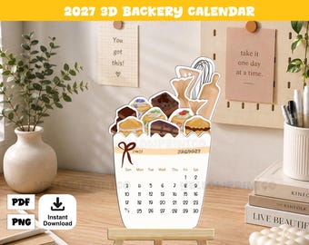 May include: A 2027 3D bakery calendar featuring a die-cut top with illustrations of various pastries, a whisk, and a rolling pin. The base displays the month of January with a grid of dates, a red bow graphic, and the year 2027 printed on the front.