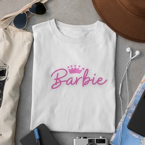  Barbie Camiseta de manga corta para mujer, Muñeca de mujer con  logotipo clásico blanco y rosa en camiseta gráfica negra