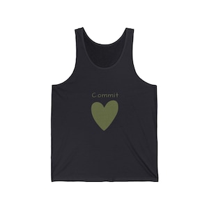 May include: Black vest top featuring the word "Commit" in light green above an olive green heart. The top is made of a soft material and has a scoop neck.