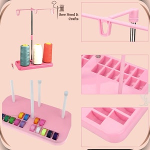 Pode incluir: Organizador de linha de costura de pl&aacute;stico rosa com m&uacute;ltiplos carret&eacute;is e bobinas. Tem um suporte com tr&ecirc;s hastes verticais e uma base com compartimentos para guardar carret&eacute;is de linha. O organizador &eacute; etiquetado como "Sew Need It Crafts".