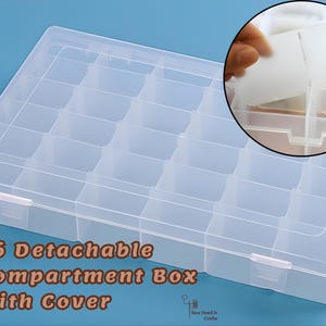 May include: A clear plastic storage box with 36 detachable compartments and a cover. The box is rectangular with a grid of small square compartments. The text "36 Detachable Compartment Box With Cover" is visible.