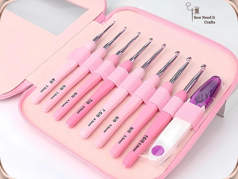 May include: A set of pink crochet hooks in a pink case. The set contains eight crochet hooks, ranging in size from 2.5mm to 6.0mm, and a purple accessory. The case is open, displaying the hooks in an organised manner.