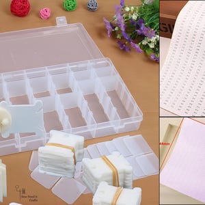 May include: A clear plastic storage box with multiple compartments, open, with a white thread winder and thread cards. The image also includes a sheet of paper with numbers and a pink grid paper, 18cm x 4.4cm.