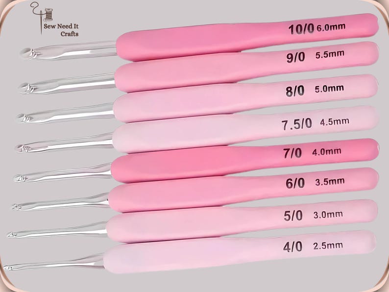 May include: A collection of eight crochet hooks with pink handles and silver hooks. Sizes range from 2.5mm to 6.0mm, each labelled with its size. The handles are in varying shades of pink.