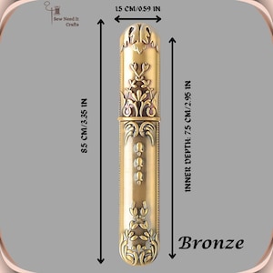 Op de afbeelding: Een naaldenkistje van brons met een sierlijk ontwerp. Het kistje is 8,5 cm hoog en 1,5 cm breed. De binnendiepte is 7,5 cm.