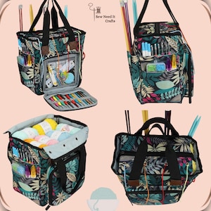 May include: A black and green tote bag with a floral pattern and multiple pockets. The bag is open and filled with yarn, knitting needles, and crochet hooks. The bag has a zipper closure and a handle. The bag is labeled "Sew Need It Crafts".