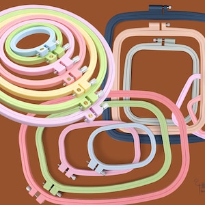 Op de afbeelding: Een verzameling ronde en rechthoekige borduurringen in diverse pastelkleuren zoals roze, lichtblauw, geel en groen, naast een donkerblauwe rechthoekige ring. Elke ring is voorzien van een metalen spanschroef voor het afstellen.