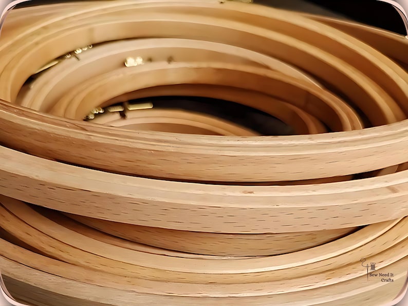 May include: A stack of wooden embroidery hoops in various sizes. The hoops are made of light-colored wood and have a smooth, curved design. The brass hardware is visible. These are ideal for embroidery and cross-stitch projects.