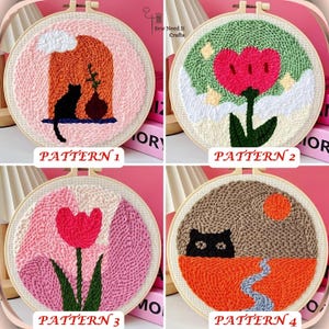 May include: Four embroidery hoop kits with different designs. The designs include a cat in a house, a flower, a tulip, and a cat in a landscape. Each hoop is made of wood and has a white background.