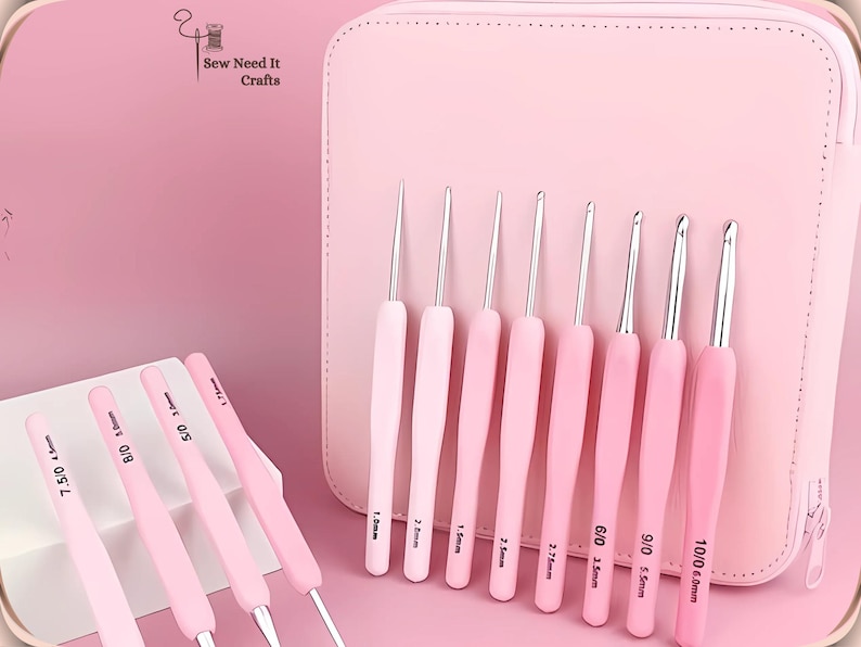 May include: A collection of pink crochet hooks with silver metal tips, displayed in front of a matching pink case. The hooks are labelled with sizes, ranging from 0.5mm to 6.0mm. The image includes the text "Sew Need It Crafts".