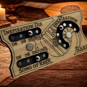 May include: Wooden game piece with the text "INSPIRATION DIE" and "BARDIC INSPIRATION BARD" engraved on it. The piece has black and silver accents and is set on a wooden surface. A candle and a glass of red wine are in the background.