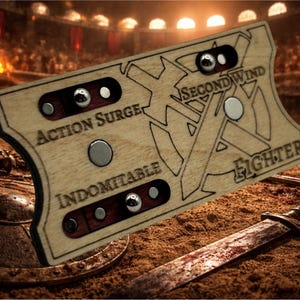 May include: A wooden game board with etched text and metal details. The board has the words "Action Surge," "Second Wind," and "Indomitable." Silver ball bearings and circular metal pieces are set into the wood. A sword and shield are in the background.