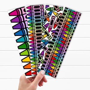 May include: A collection of colorful crayon-themed bookmarks. Each bookmark features a different pattern of crayons in various colors, including pink, purple, blue, green, yellow, and orange. The background is white with a wood grain pattern.