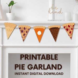 May include: Printable pie garland featuring five different pie designs. The garland is strung on a white fireplace mantel. The text "be kind" is visible above the garland. The text "Printable Pie Garland Instant Digital Download" is visible below the garland.