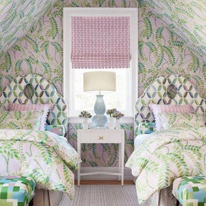 May include: A bedroom with matching twin beds, featuring patterned headboards and bedding with green and white leaf designs. The room has a matching wallpaper, a white nightstand, and a window with a pink shade. Two patterned benches sit at the foot of the beds.