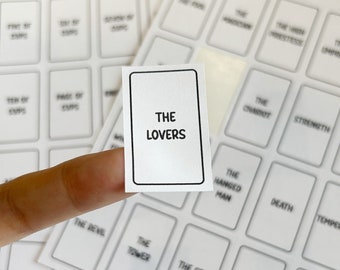 May include: A white sticker with black text that reads "THE LOVERS". The sticker is part of a set of tarot card stickers.