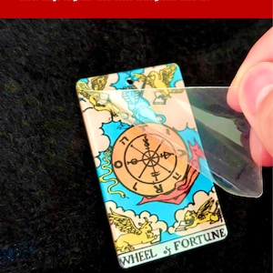 May include: A colorful tarot card with the Wheel of Fortune design. The card is made of acrylic and has a protective layer that needs to be removed for best results.