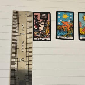 May include: Three tarot cards with colorful illustrations and text. The cards are "Death", "The Star", and "The Moon".