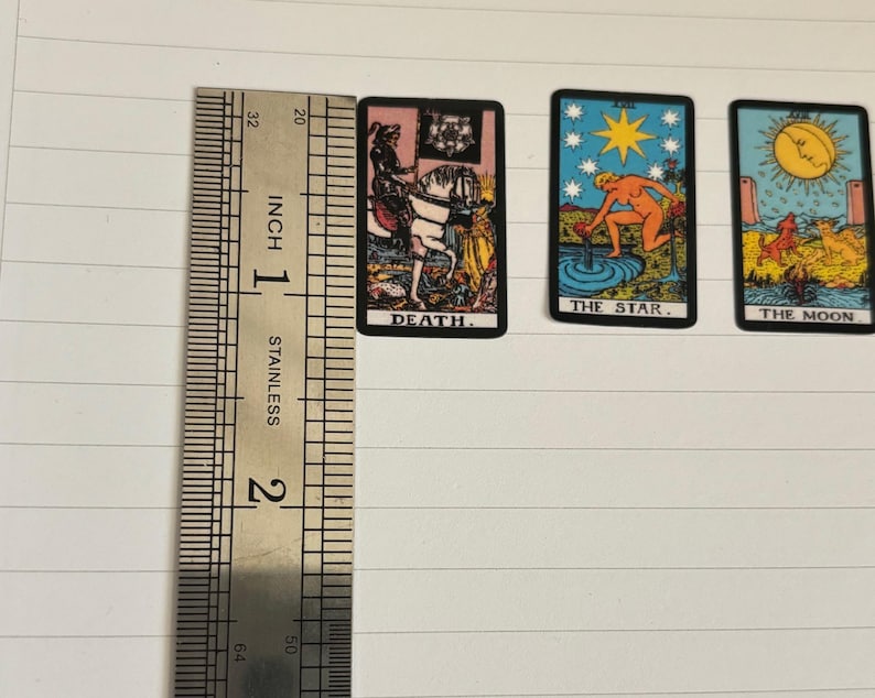 May include: Three tarot cards with colorful illustrations and text. The cards are "Death", "The Star", and "The Moon".