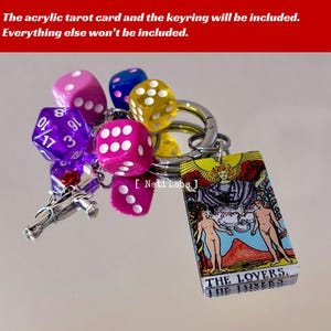 May include: A keychain with a colorful acrylic tarot card featuring the Lovers card, a silver horse charm, and several colorful dice. The card has the text "THE LOVERS." and "THE LOVERS" on it.