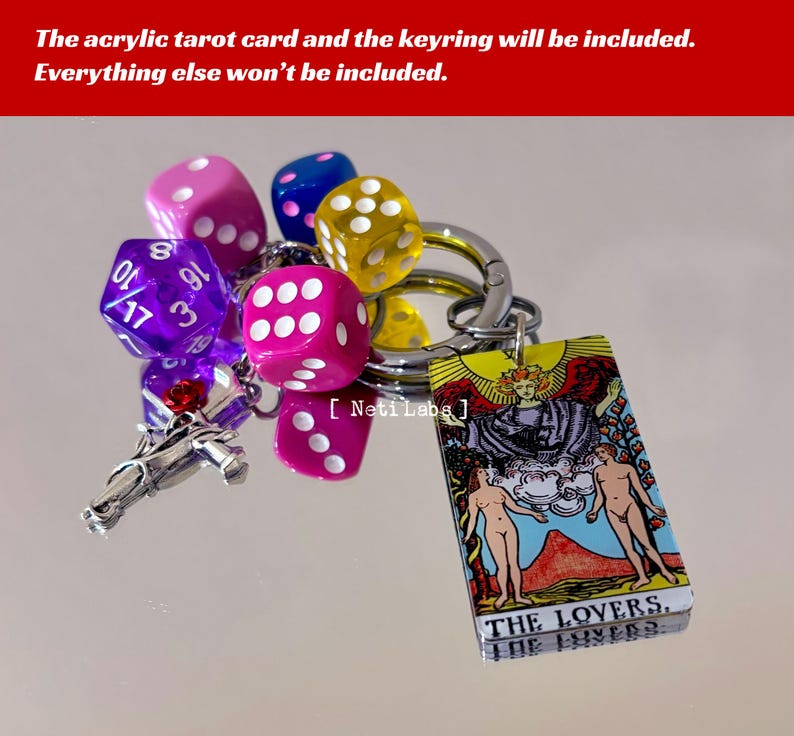 May include: A keychain with a colorful acrylic tarot card featuring the Lovers card, a silver horse charm, and several colorful dice. The card has the text "THE LOVERS." and "THE LOVERS" on it.