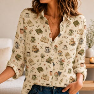 May include: A long-sleeved button-down shirt in a cream color featuring an all-over print of books, coffee cups, floral arrangements, and eyeglasses. The shirt has a classic collar, a front button placket, and sleeves rolled up to the elbows.