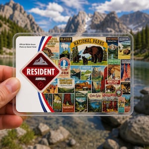 May include: A rectangular National Parks annual resident pass featuring a collage of vintage-style illustrations of various parks, including a large brown bear, with a red and white diamond-shaped logo that reads RESIDENT ANNUAL and a mountain icon.