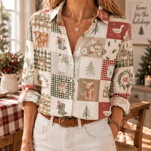 Könnte beinhalten: Ein langärmeliges Hemd mit Knopfleiste und einem Patchwork-Muster aus weihnachtlichen Illustrationen wie Kühen, Gänsen, Tannenbäumen und Stiefeln in Grün-, Rot- und Cremetönen, kombiniert mit einem braunen Ledergürtel und einer weißen Hose.
