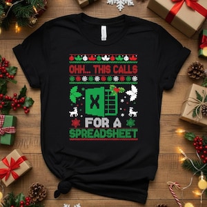 以下が含まれることがあります： お祝いのデザインの黒いTシャツ。「OHH... THIS CALLS FOR A SPREADSHEET」のテキストがクリスマスのセーターのスタイルで表示されています。デザインには雪の結晶、トナカイ、緑色のExcelスプレッドシートグラフィックが含まれています。