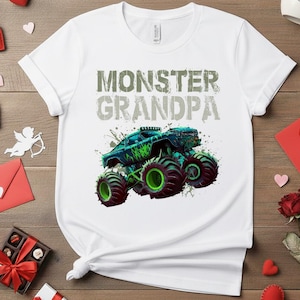 May include: White t-shirt with the text "MONSTER GRANDPA" in distressed green and gray lettering. A graphic of a monster truck in shades of blue and green is featured below the text.