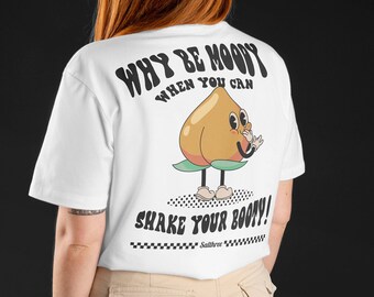 以下が含まれることがあります： 背中に漫画の桃のグラフィックが描かれた白いTシャツ。桃は笑顔で靴を履いています。「WHY BE MOODY WHEN YOU CAN SHAKE YOUR BOOTY！」というテキストが上と下にあります。
