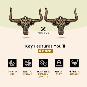 May include: Two bronze-toned metal bull head wall hooks with curved horns and a mounting hole at the top. The design features detailed facial textures and a weathered finish. The text ZUHSAN is centered below the hooks, followed by Key Features You'll Adore and five icons representing ease of use, installation, durability, heavy-duty capacity, and realistic design.