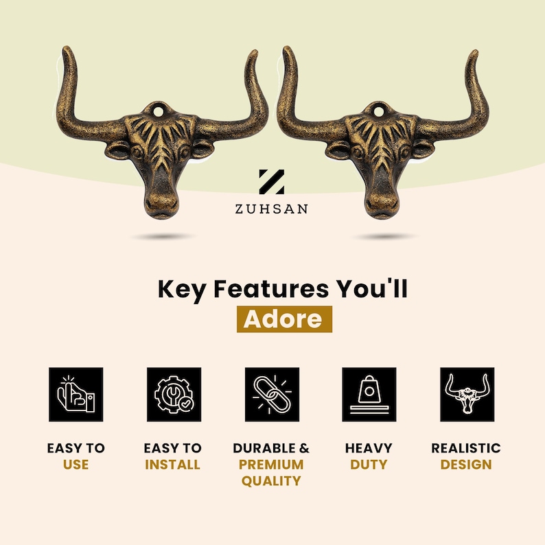 May include: Two bronze-toned metal bull head wall hooks with curved horns and a mounting hole at the top. The design features detailed facial textures and a weathered finish. The text ZUHSAN is centered below the hooks, followed by Key Features You'll Adore and five icons representing ease of use, installation, durability, heavy-duty capacity, and realistic design.