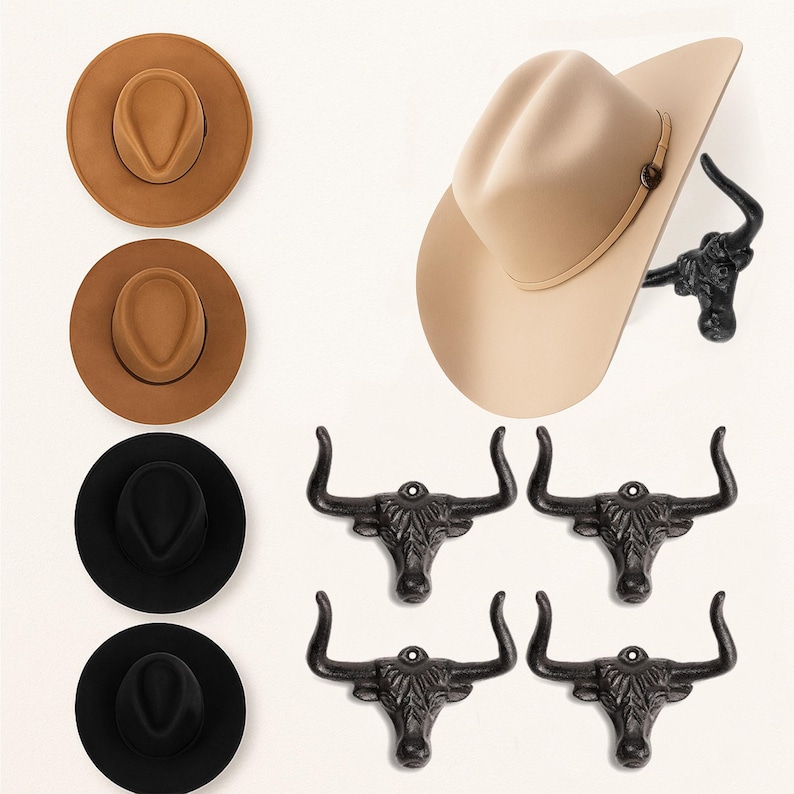 May include: Four wide-brimmed hats in tan, brown, and black colors, paired with four black cast iron wall hooks shaped like longhorn steer heads. One hat is shown resting on a steer head hook, while the others are displayed separately.