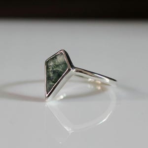 Peut inclure: Une bague en argent avec une pierre d'agate mousse verte sertie en forme de diamant.