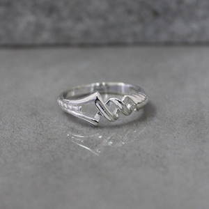 May include: A silver ring with a twisted design. The ring is open on one side and has a unique, geometric shape.