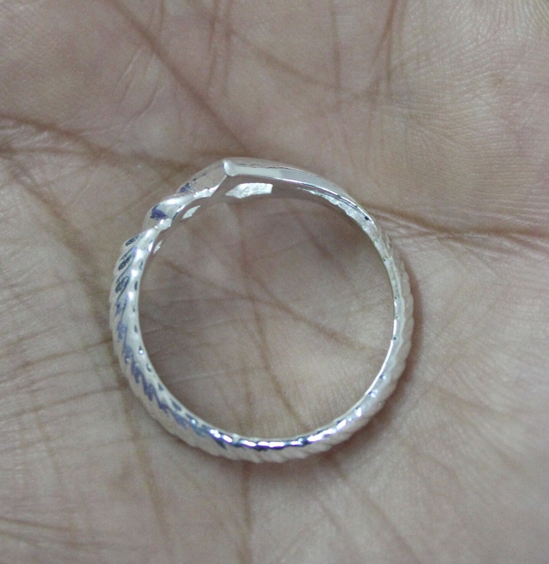 May include: A silver ring with a twisted band and a textured finish.
