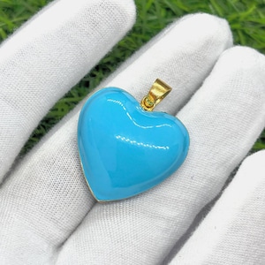 May include: A gold heart-shaped pendant with a light blue enamel finish.