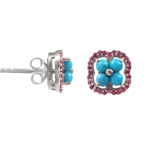 Może przedstawiać: Para srebrnych kolczyków sztyftów. Każdy kolczyk ma skupisko czterech turkusowych kamieni w kształcie kwiatu, otoczone obramowaniem z małych, różowych kamieni szlachetnych. Kolczyki mają sztyft i zapięcie motylkowe.