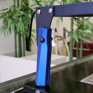 May include: A blue and black 3D printed adjustable arm for a desk lamp. The arm is attached to a black metal base.