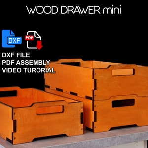 Può includere: Tre cassetti in legno di colore arancione con finiture nere. I cassetti sono impilati uno sopra l'altro. Il cassetto superiore ha una maniglia. L'immagine include il testo "WOOD DRAWER mini", "DXF FILE", "PDF ASSEMBLY" e "VIDEO TUTORIAL".